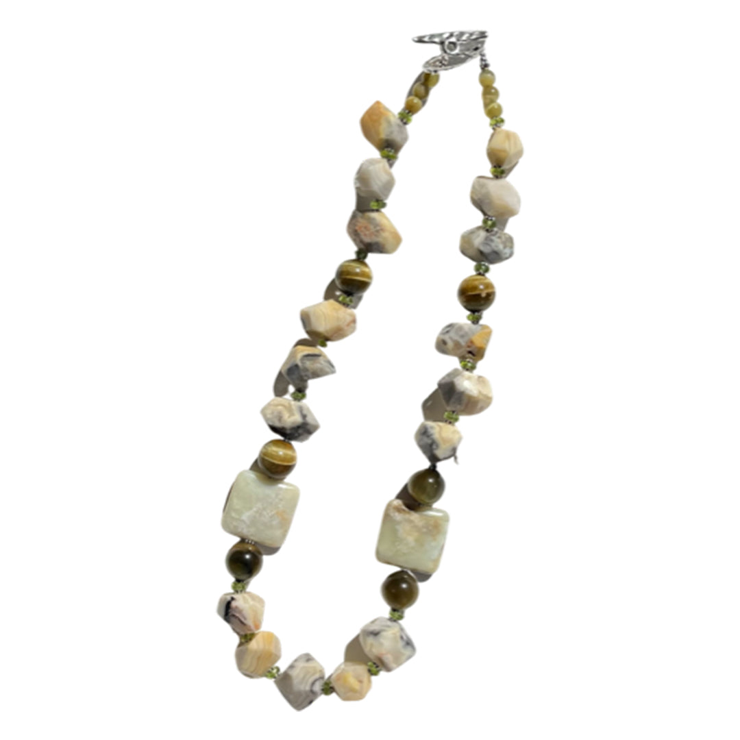 A 20-inch beaded necklace featuring a variety of geometric shaped beads in shades of brown, black, and white, with silver accents.