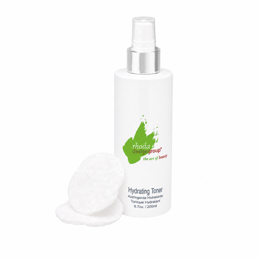 A white bottle of Rhoda Design Group's Hydrating Toner with a silver spray nozzle, shown on a white background with two cotton pads in front.